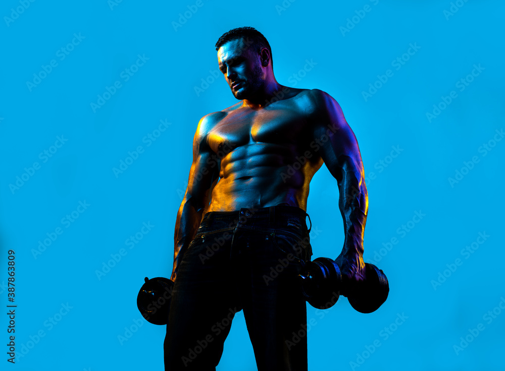 Muscular man exercises with dumbbells. Sexy guy.