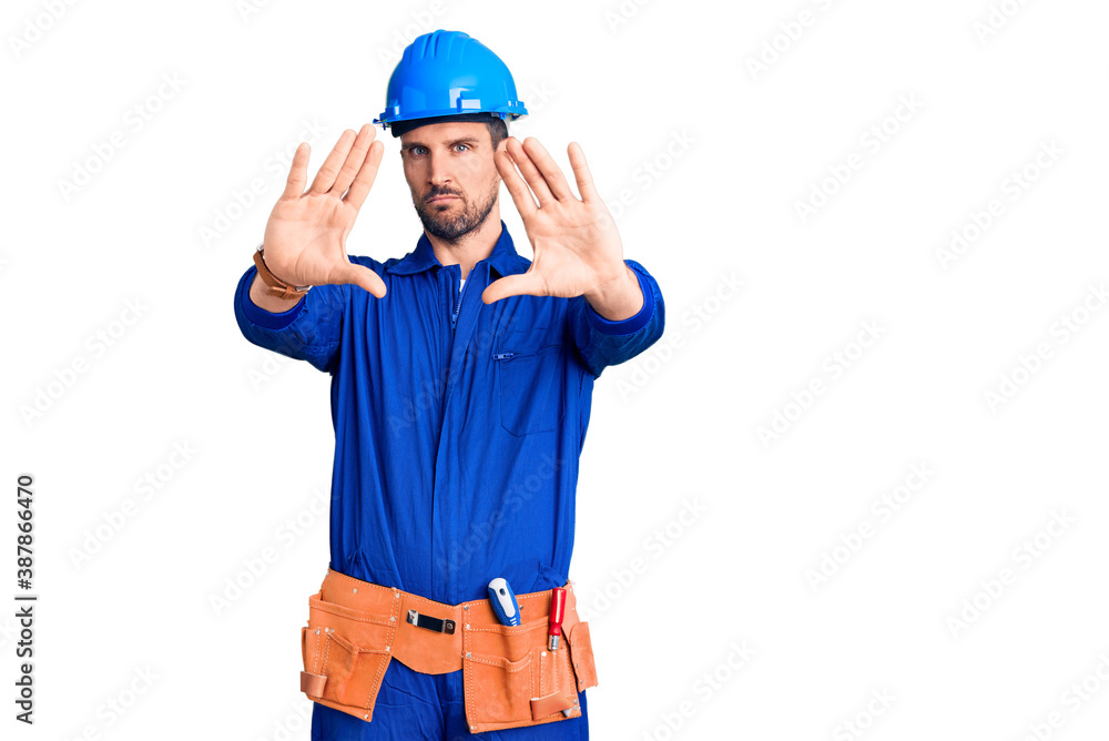 Young handsome man wearing worker uniform and hardhat thinking looking tired and bored with depression problems with crossed arms.