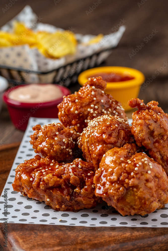 Baked chicken wings with sesame and sauce on wooden background Baked chicken wings with sesame and sauce on wooden background