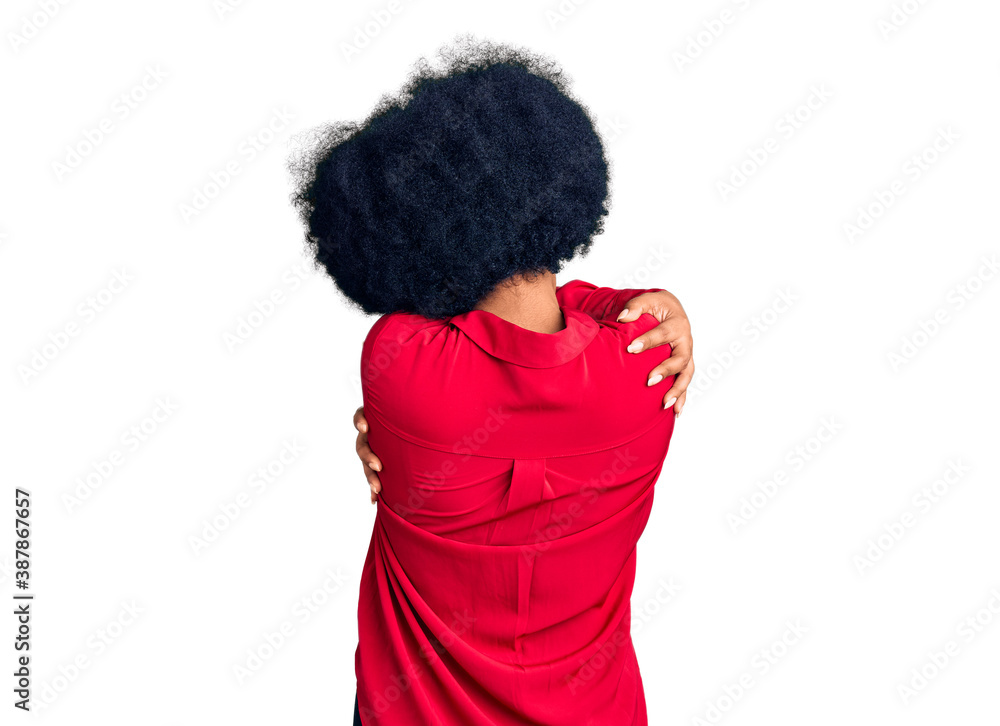 Young african american girl wearing casual clothes hugging oneself happy and positive from backwards. self love and self care Young african american girl wearing casual clothes hugging oneself happy and positive from backwards. self love and self care