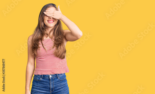 Beautiful caucasian young woman wearing casual clothes smiling and laughing with hand on face covering eyes for surprise. blind concept.