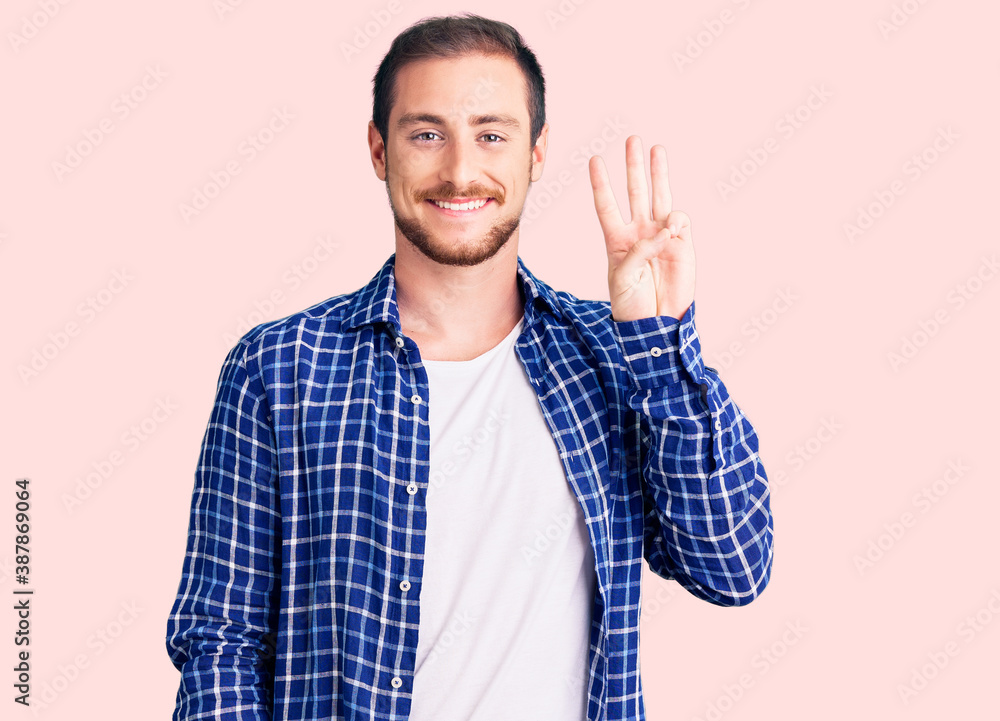 Young handsome caucasian man wearing casual clothes showing and pointing up with fingers number three while smiling confident and happy.