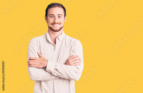 Young handsome caucasian man wearing casual clothes happy face smiling with crossed arms looking at the camera. positive person.