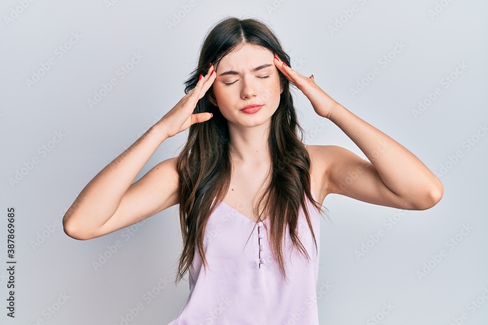 Young beautiful caucasian girl wearing casual clothes with hand on head, headache because stress. suffering migraine. Young beautiful caucasian girl wearing casual clothes with hand on head, headache because stress. suffering migraine.
