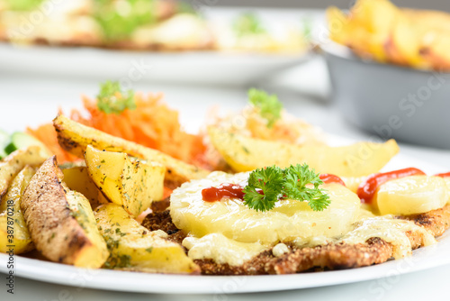 cutlet with pineapple and baked potatoes with bouquet of salads