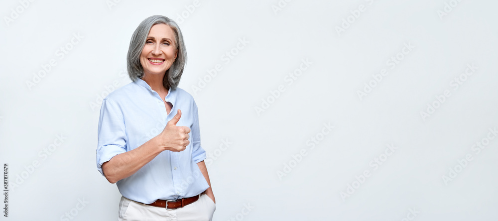 Φωτογραφία Smiling older mature businesswoman employer showing thumbs up like hand gesture standing isolated on white background advertising good best business service recommendation concept, banner, copy space