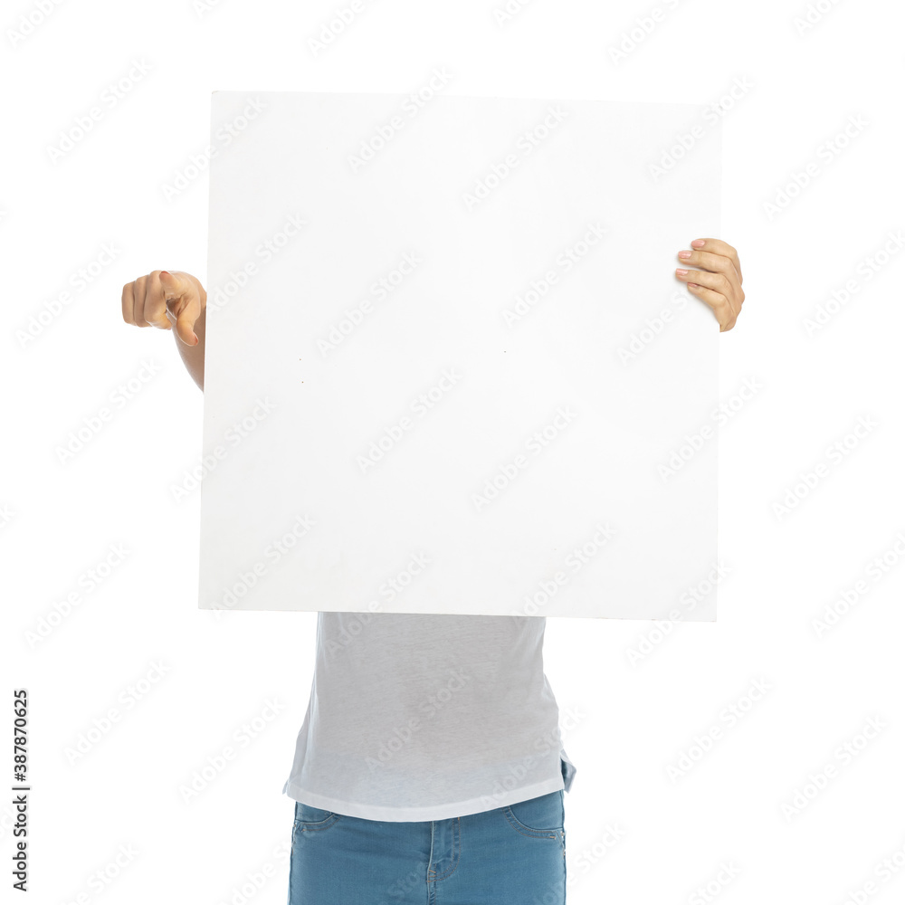 Young casual woman covering face with billboard, pointing Young casual woman covering face with billboard, pointing
