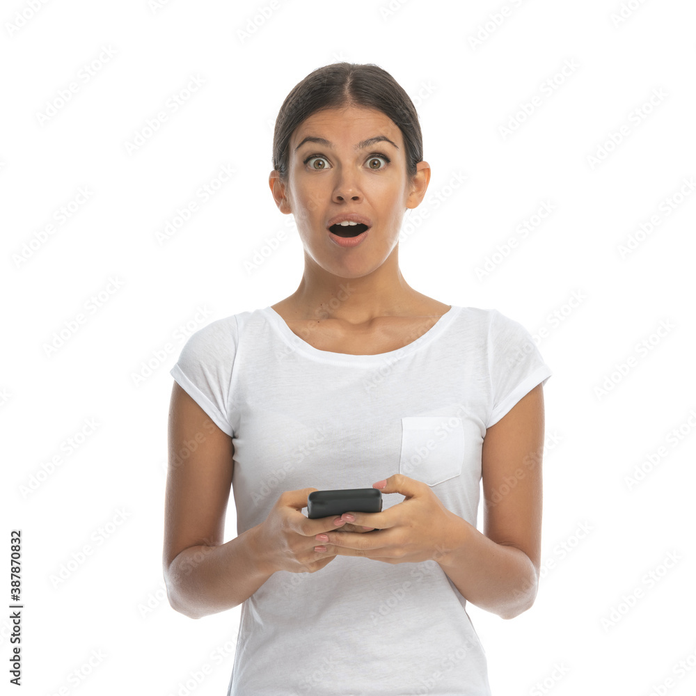 Surprised casual woman holding phone and gasping Surprised casual woman holding phone and gasping