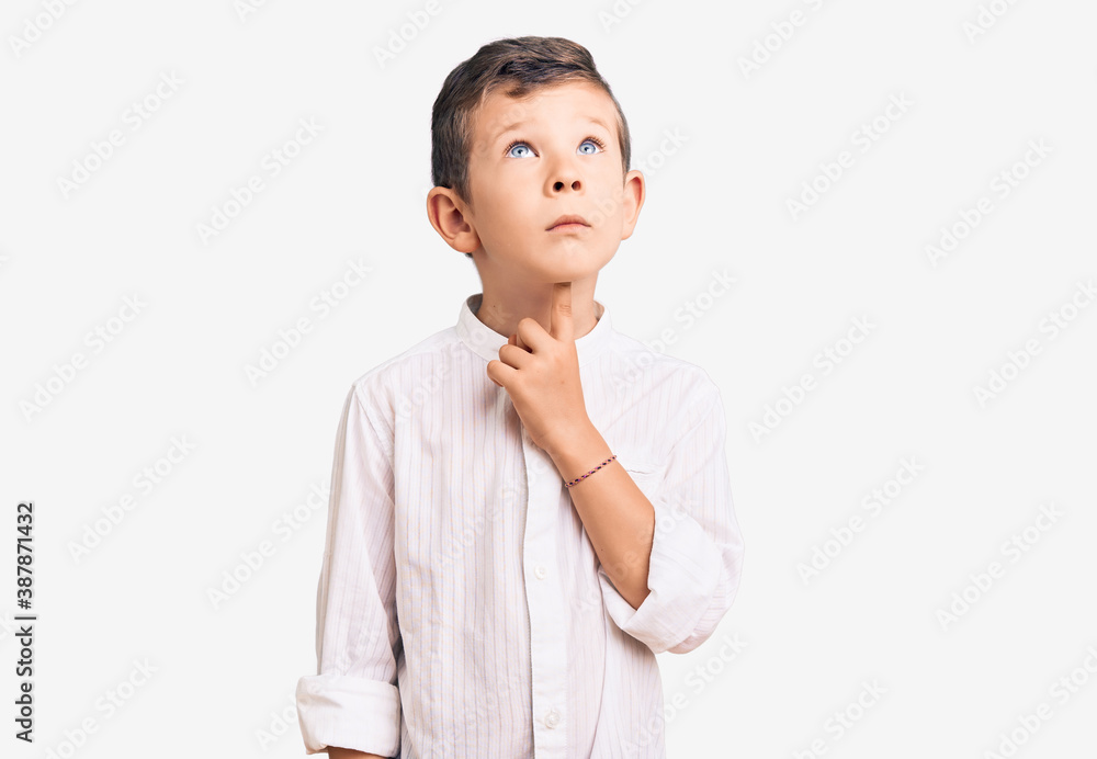 Cute blond kid wearing elegant shirt thinking concentrated about doubt with finger on chin and looking up wondering Cute blond kid wearing elegant shirt thinking concentrated about doubt with finger on chin and looking up wondering