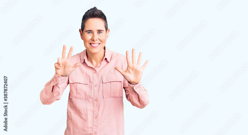 Young woman with short hair wearing casual clothes showing and pointing up with fingers number eight while smiling confident and happy. Young woman with short hair wearing casual clothes showing and pointing up with fingers number eight while smiling confident and happy.