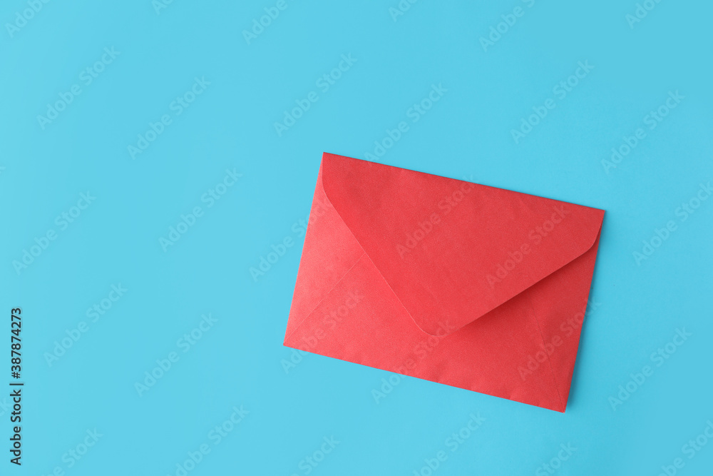 Red paper envelope on light blue background, top view. Space for text Red paper envelope on light blue background, top view. Space for text