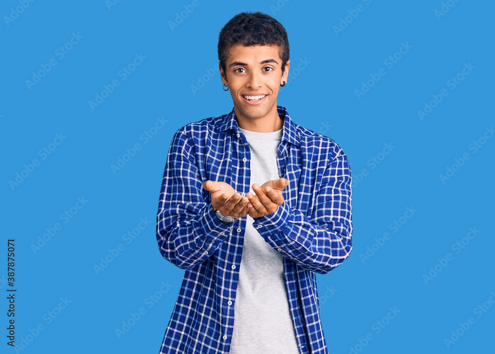 Young african amercian man wearing casual clothes smiling with hands palms together receiving or giving gesture. hold and protection Young african amercian man wearing casual clothes smiling with hands palms together receiving or giving gesture. hold and protection