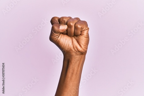 Bilde på lerret Arm and hand of black middle age woman over pink isolated background doing prote