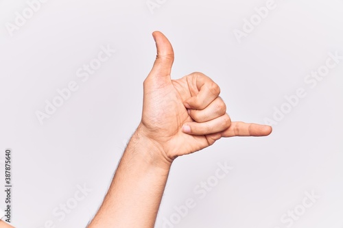 Close up of hand of young caucasian man over isolated background gesturing hawaiian shaka greeting gesture, telephone and communication symbol