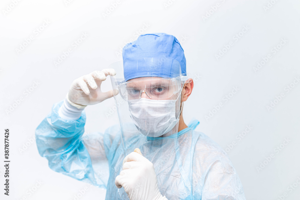 surgeon doctor in protective uniform, glasses and face shield dressed to fight the coronavirus epidemic. surgeon doctor in protective uniform, glasses and face shield dressed to fight the coronavirus epidemic.