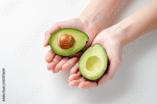 
Young woman holding avocado in her hands. Healthy food