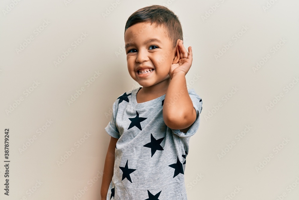 Φωτογραφία Adorable latin toddler wearing casual clothes smiling with hand over ear listening and hearing to rumor or gossip