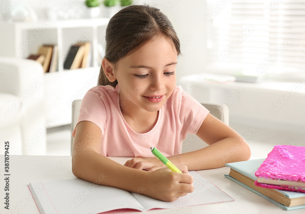 Little girl doing homework at table indoors Little girl doing homework at table indoors