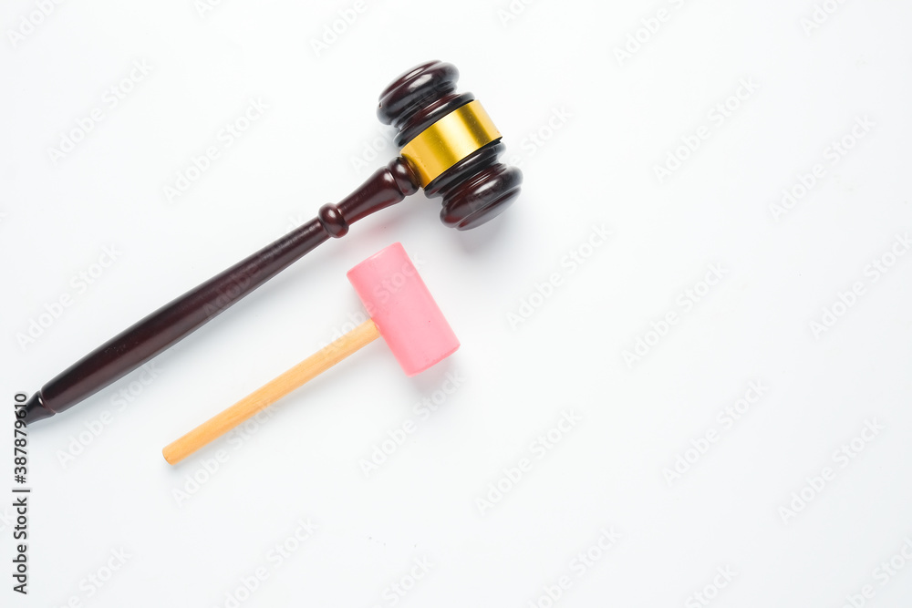 A flatlay picture of gavel and toy hammer on copyspace white background for ambition concept. The ambition of this kid to be a law judge.