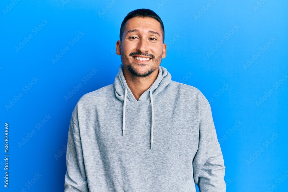 Handsome man with tattoos wearing casual sweatshirt with a happy and cool smile on face. lucky person. Handsome man with tattoos wearing casual sweatshirt with a happy and cool smile on face. lucky person.