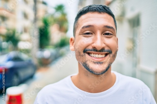 Young hispanic man smiling happy walking at street of city. © Krakenimages.com