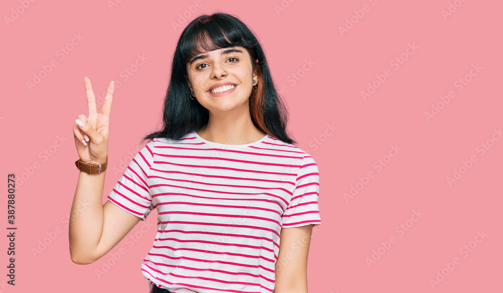 Young hispanic girl wearing casual clothes smiling looking to the camera showing fingers doing victory sign. number two. Young hispanic girl wearing casual clothes smiling looking to the camera showing fingers doing victory sign. number two.