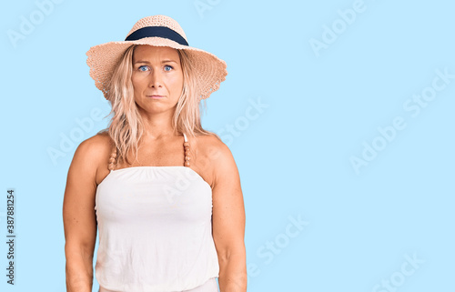 Middle age fit blonde woman wearing summer hat depressed and worry for distress, crying angry and afraid. sad expression.