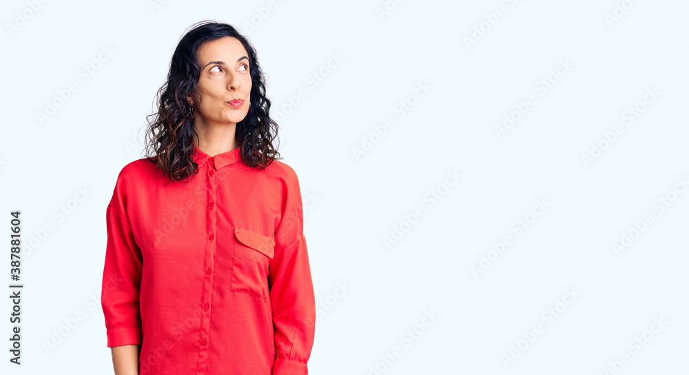 Young beautiful hispanic woman wearing casual clothes smiling looking to the side and staring away thinking. Young beautiful hispanic woman wearing casual clothes smiling looking to the side and staring away thinking.