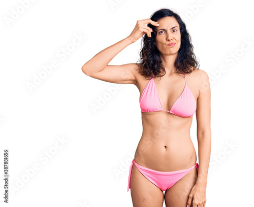 Young beautiful hispanic woman wearing bikini worried and stressed about a problem with hand on forehead, nervous and anxious for crisis © Krakenimages.com