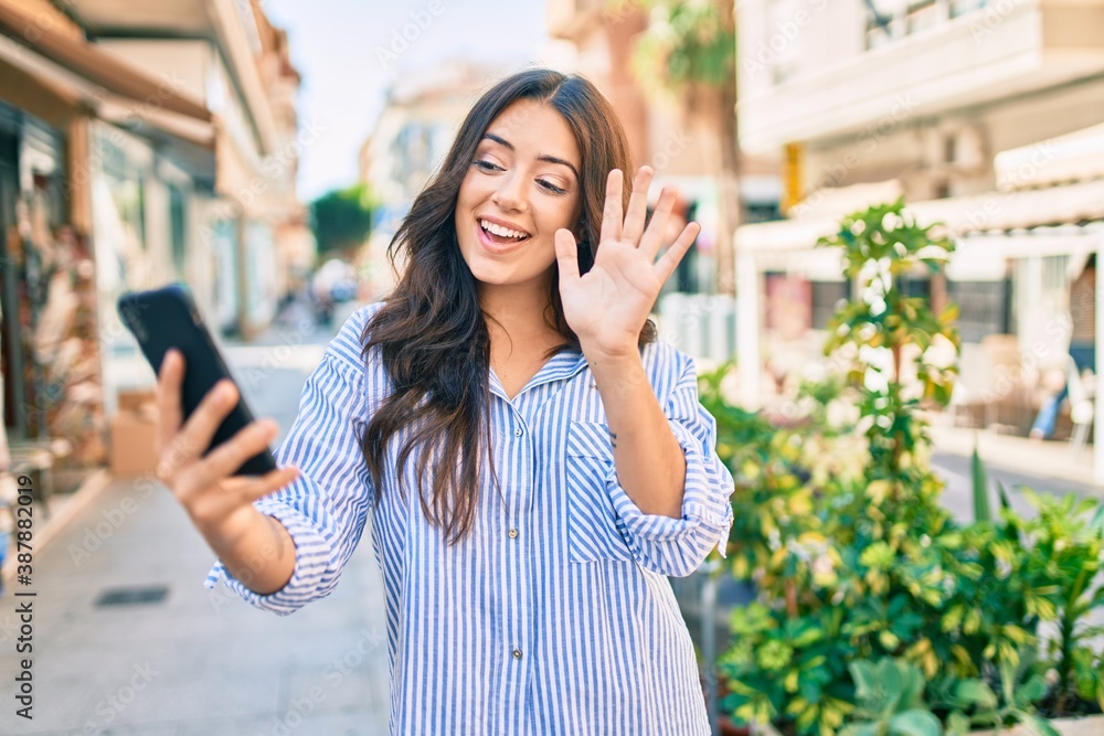 Young hispanic businesswoman smiling happy doing video call using smartphone at the city. Young hispanic businesswoman smiling happy doing video call using smartphone at the city.