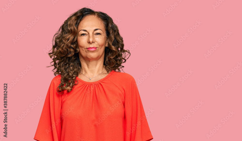 Middle age hispanic woman wearing casual clothes with serious expression on face. simple and natural looking at the camera. Middle age hispanic woman wearing casual clothes with serious expression on face. simple and natural looking at the camera.