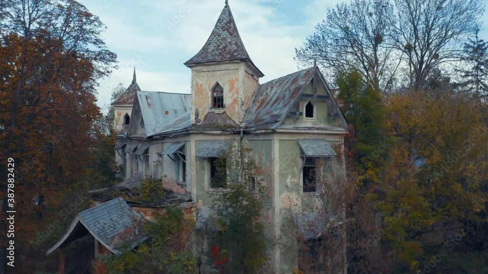 Abandoned 19th-century Victorian haunted house (ghost house) in a dense autumn forest. Aerial view. Abandoned 19th-century Victorian haunted house (ghost house) in a dense autumn forest. Aerial view.
