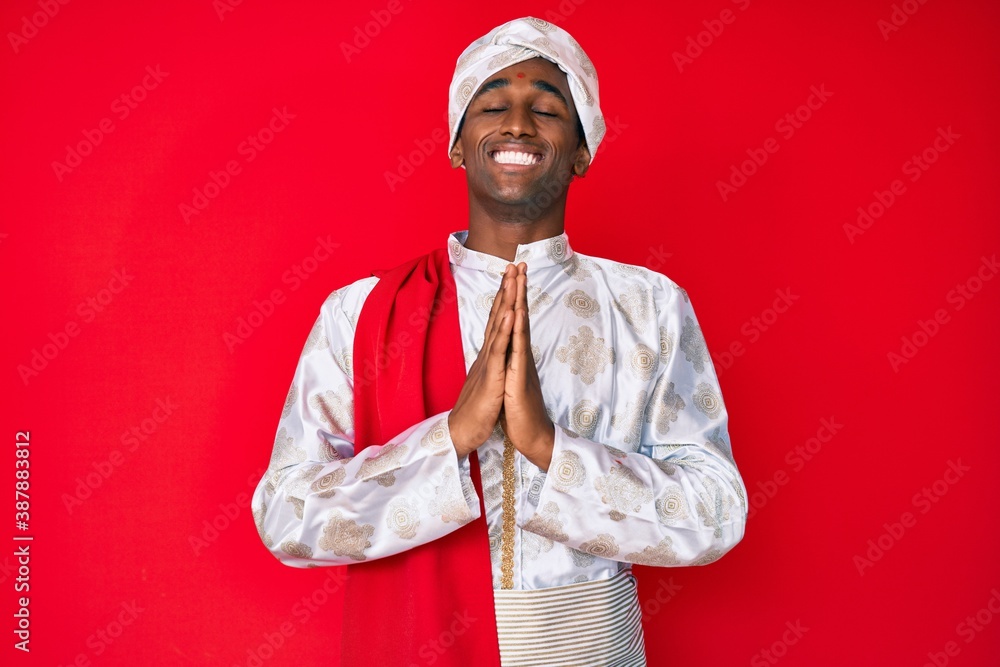 Handsome indian man wearing tradition sherwani saree clothes begging and praying with hands together with hope expression on face very emotional and worried. begging. Handsome indian man wearing tradition sherwani saree clothes begging and praying with hands together with hope expression on face very emotional and worried. begging.