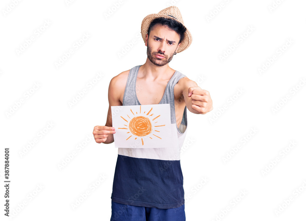 Young hispanic man wearing summer hat holding sun draw annoyed and frustrated shouting with anger, yelling crazy with anger and hand raised Young hispanic man wearing summer hat holding sun draw annoyed and frustrated shouting with anger, yelling crazy with anger and hand raised