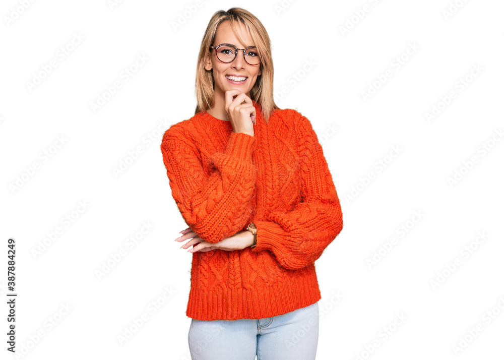 Beautiful blonde woman wearing casual clothes and glasses looking confident at the camera smiling with crossed arms and hand raised on chin. thinking positive. Beautiful blonde woman wearing casual clothes and glasses looking confident at the camera smiling with crossed arms and hand raised on chin. thinking positive.