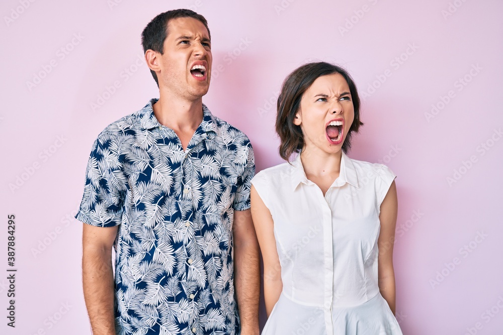 Beautiful couple wearing casual clothes angry and mad screaming frustrated and furious, shouting with anger. rage and aggressive concept. Beautiful couple wearing casual clothes angry and mad screaming frustrated and furious, shouting with anger. rage and aggressive concept.