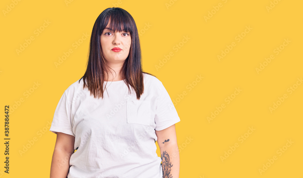 Young plus size woman wearing casual clothes relaxed with serious expression on face. simple and natural looking at the camera. Young plus size woman wearing casual clothes relaxed with serious expression on face. simple and natural looking at the camera.