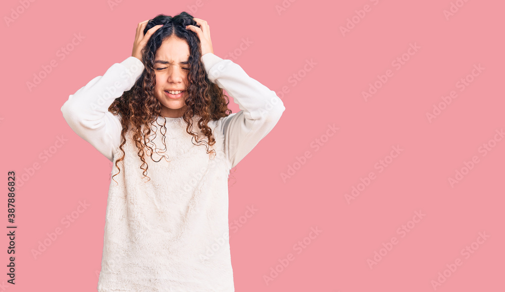 Beautiful kid girl with curly hair wearing casual clothes suffering from headache desperate and stressed because pain and migraine. hands on head. Beautiful kid girl with curly hair wearing casual clothes suffering from headache desperate and stressed because pain and migraine. hands on head.