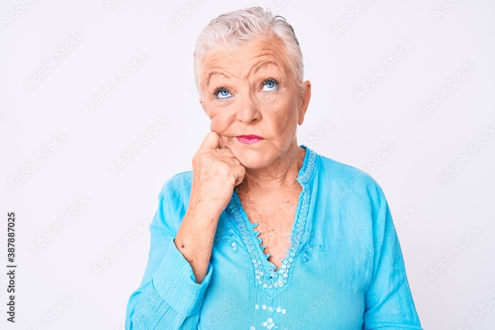 Senior beautiful woman with blue eyes and grey hair wearing summer clothes thinking concentrated about doubt with finger on chin and looking up wondering Senior beautiful woman with blue eyes and grey hair wearing summer clothes thinking concentrated about doubt with finger on chin and looking up wondering
