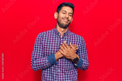 Young latin man wearing casual clothes smiling with hands on chest, eyes closed with grateful gesture on face. health concept.