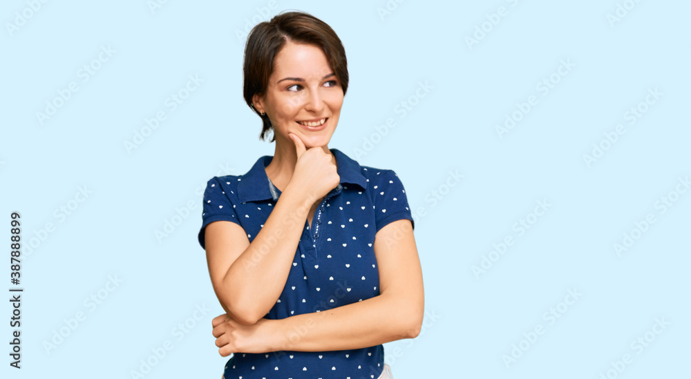 Young brunette woman with short hair wearing casual clothes with hand on chin thinking about question, pensive expression. smiling with thoughtful face. doubt concept. Young brunette woman with short hair wearing casual clothes with hand on chin thinking about question, pensive expression. smiling with thoughtful face. doubt concept.
