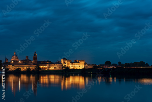 Panorama of the city of Mantua illuminated and reflected in the lake water