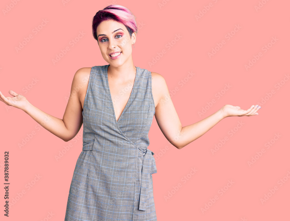 Young beautiful woman with pink hair wearing casual clothes smiling showing both hands open palms, presenting and advertising comparison and balance Young beautiful woman with pink hair wearing casual clothes smiling showing both hands open palms, presenting and advertising comparison and balance