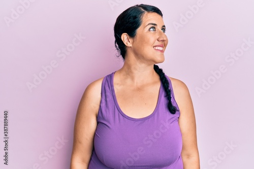 Plus size brunette woman wearing sportswear looking to side, relax profile pose with natural face and confident smile.