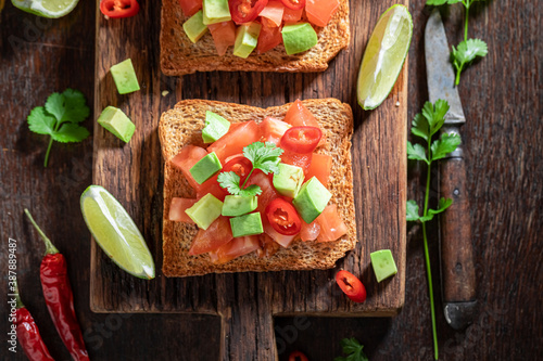 Rustic Toast made of tomatoes, chilli pepper and avocado