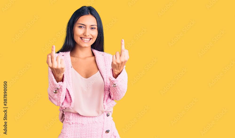 Young beautiful latin girl wearing business clothes showing middle finger doing fuck you bad expression, provocation and rude attitude. screaming excited Young beautiful latin girl wearing business clothes showing middle finger doing fuck you bad expression, provocation and rude attitude. screaming excited