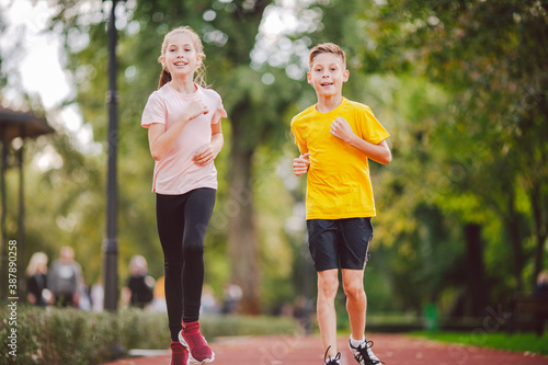 Kids run. Healthy sport. Child sport  heterosexual twins running on track  fitness. Joint training. Running training outdoor brother and sister pre-teen. Jogging with friend. Children athletes