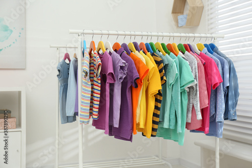 Different child's clothes hanging on racks indoors © New Africa