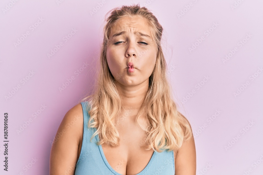 Young blonde girl wearing casual clothes making fish face with lips, crazy and comical gesture. funny expression. Young blonde girl wearing casual clothes making fish face with lips, crazy and comical gesture. funny expression.