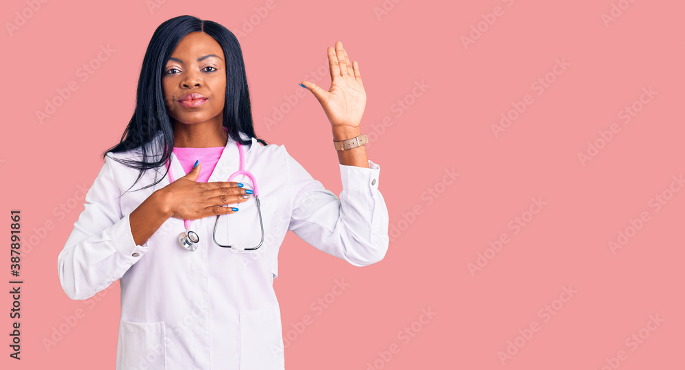 Young african american woman wearing doctor stethoscope swearing with hand on chest and open palm, making a loyalty promise oath Young african american woman wearing doctor stethoscope swearing with hand on chest and open palm, making a loyalty promise oath